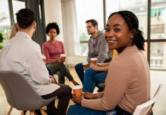 Group of people meeting with one woman smiling at camera